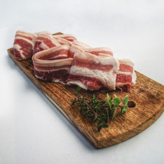 Food photography of sliced bacon on top of brown chopping 1927377